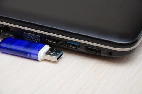 Blue USB flash drive or connected to laptop computer's USB port. Notebook is  Stock Photos