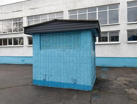 Blue utility structure serving a ventilation system outside a Soviet era sc.. 库存照片
