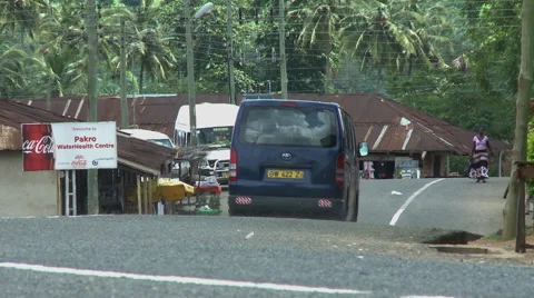 BLUE VAN DRIVES DOWN PAKRO ROAD Stock Footage 58074841