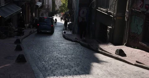 Blue van drives down a steep cobblestone street in moody Istanbul side alley Stock Footage 321035763