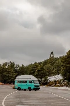 A blue van maneuvers through a winding road under the sky Foto stock