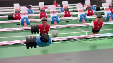 Blue versus red team in table football soccer match with ball Stock Footage 332745877