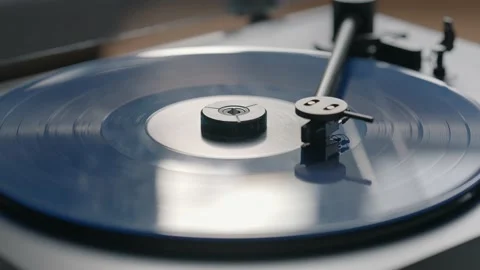 Blue vinyl record spinning and playing music on a black gramophone Stock Footage 220356779