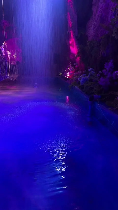 A blue-violet neon waterfall with a reflecting pool  Stock Footage 336407956