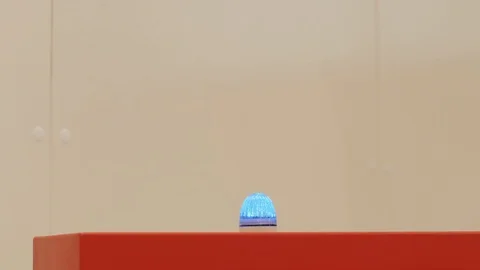 Blue warning blinking light alarm on red stand, manufacture Stock Footage 117831602