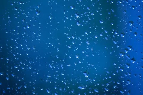 Blue water drops on a window Stock Photos