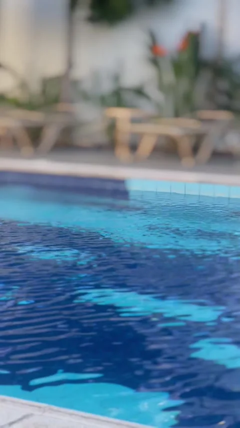 Blue water gently flows in a pool with lush greenery in the background Stock Footage 288073388