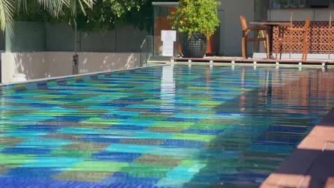 Blue water gently flows in a pool with lush greenery in the background Stock Footage 292922368