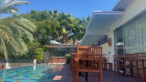Blue water gently flows in a pool with lush greenery in the background Stock Footage 292922372