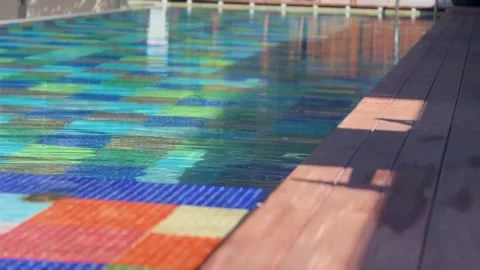 Blue water gently flows in a pool with lush greenery in the background Video stock 292922374