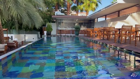 Blue water gently flows in a pool with lush greenery in the background Stock Footage 292922379