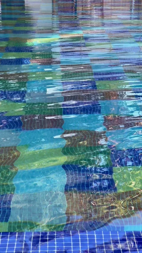 Blue water gently flows in a pool with lush greenery in the background Stock Footage 292922397