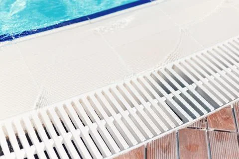 Blue water with light reflection at the edge of the curved swimming pool. The Stock Photos