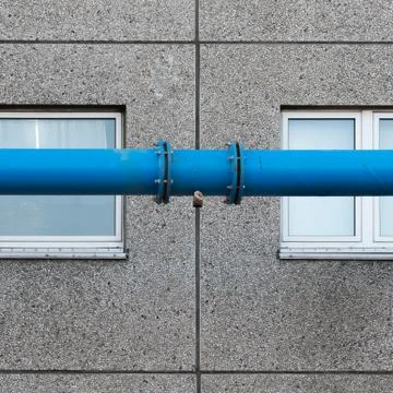 The blue water pipe in front of the windows of the prefabricated house Stock Photos