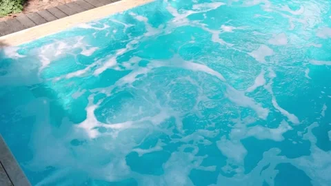 Blue water in a pool bubbles with the hydro massage system turned on, creating f Stock Footage 312748379