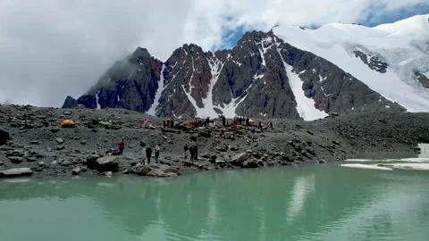 Blue water with snow floating in it in front of mountain Stock Footage 212196394