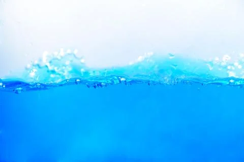 Blue water surface with air bubbles and splashes. Abstract background. Stock Photos