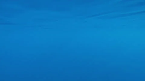 Blue water surface during calms, with oblique sun rays of light penetrating Stock Footage 339973871