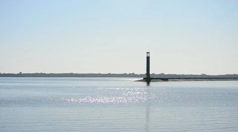 Blue water surface glitters and sparkles in sun with lighthouse Stock Footage 54783574