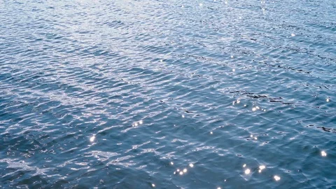 Blue water surface with ripple, sun glares on lake at sunny day in slow motion Video stock 126895174