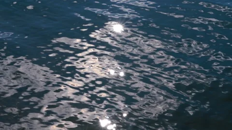 Blue water surface with ripple, sun glares on lake at sunny day Video stock 126895573