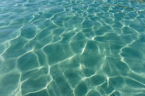 Blue water surface with sun reflections. Background and texture for design. Stock Photos