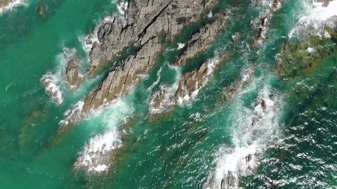 Blue water waves breaking over interesting rocky coastline Stock Footage 94484146