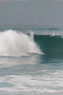 Blue wave breaking on the beach 스톡 사진
