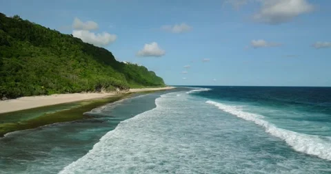 Blue wave crashes on the sandy beach with jungle in Bali Видео 273846610