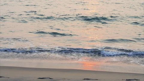 Blue waves on the beach at sunset Fotos Stock