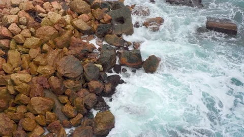 Blue waves of the black sea, beating brown rocks. Sea foam top view. Stones Stock Footage 143802905