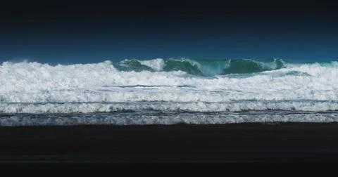 Blue waves crash down on beach in Cornwall, UK Stock Photos