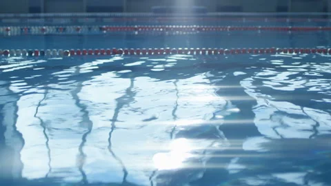 Blue waves in the pool shimmer with bright light from the incident sunlight Stock Footage 119499468
