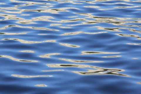 Blue waves of the river adorned with sunlight Stock Photos