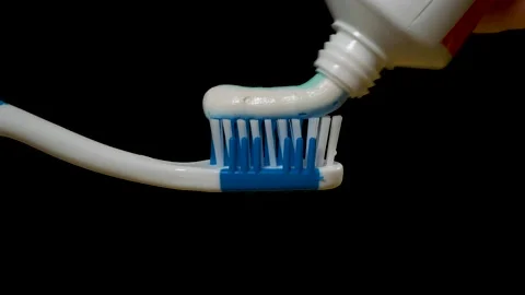 Blue-white-green toothpaste is squeezed onto a toothbrush Stock Footage 214426870