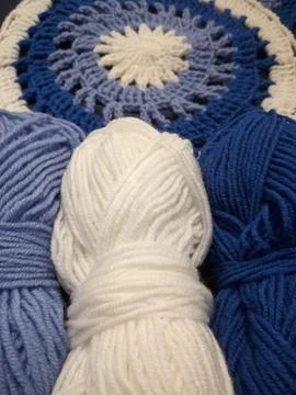 Blue, white round crochet elements and balls of yarn. Crochet texture, place  Stock Photos