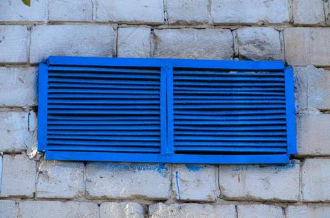 A blue window with a blue grate on it.  Stock Photos
