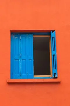 Blue window in red wall Stock Photos