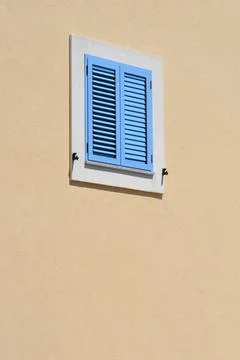Blue window shutters on a beige wall Stock Photos