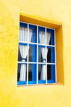 Blue window, yellow facade Stock Photos