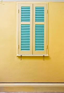 Blue window on yellow  wall. Stock Photos