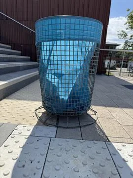 A blue wire trash bin along the pathway boosts both aesthetics and functionality Stock Photos