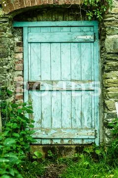 Blue wooden door in a stone wall Stock Photos