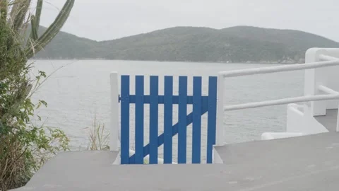 A blue wooden gate opening onto a path leading to the beach Stock Footage 342572128