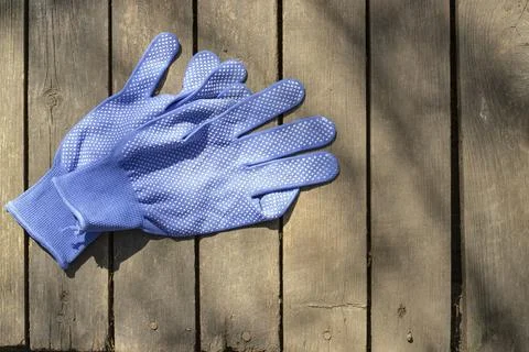 Blue work gloves on old boards, top view Stock Photos