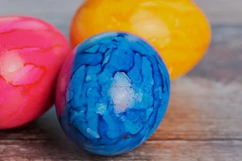 Blue, yellow and pink easter egg on wooden surface Stock Photos