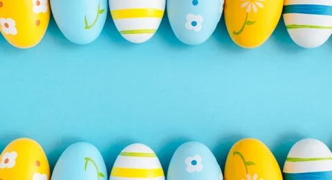 Blue, yellow and white Easter eggs on a light blue background. 库存照片