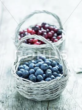 Blueberries and cranberries in baskets Stock Photos