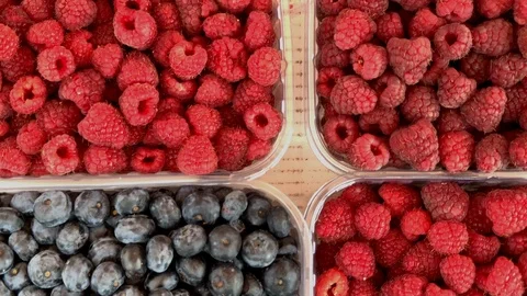 Blueberries and raspberries in plastic boxes for sale, close up view Stock Footage 117102405