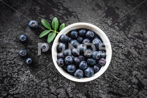 Blueberries in bowl on black concrete background Stock Photos